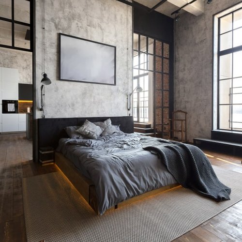 Industrial style bedroom with dark hardwood flooring